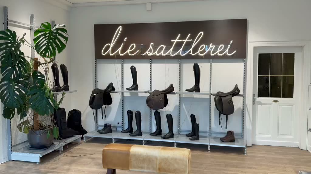 Ladengeschäft mit Neon-Schrift, Sätteln und Reitstiefeln